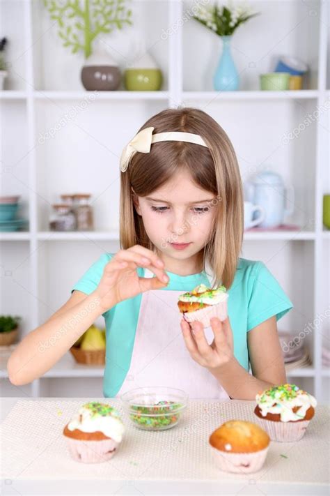 Little girl decorating cupcakes in kitchen at home — Stock Photo ...