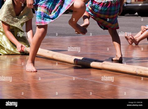 Filipino Tinikling dancers maneuvering around bamboo poles Stock Photo - Alamy