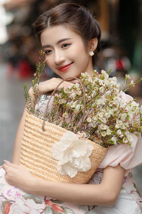 a woman holding a basket with flowers in it