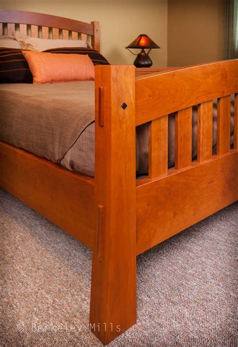 a wooden bed frame in a bedroom with carpeted flooring and walls behind it