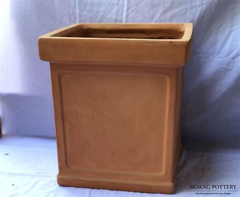 A simple tall square terracotta planter with thick rim in orange color ...