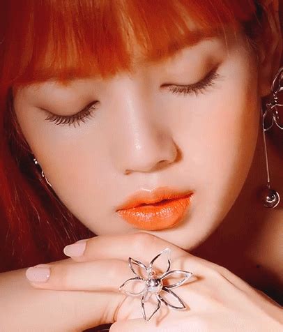 a woman with red hair and piercings on her fingers