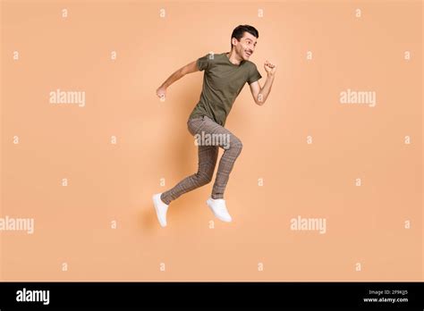 Full size profile side photo of young happy cheerful excited man running fast in air isolated on ...