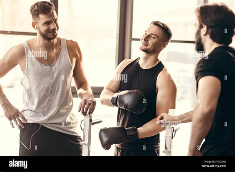 three sporty young men on sportswear talking in gym Stock Photo - Alamy