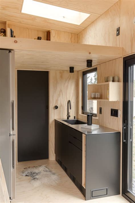 the interior of a tiny home with wood paneling and black appliances ...