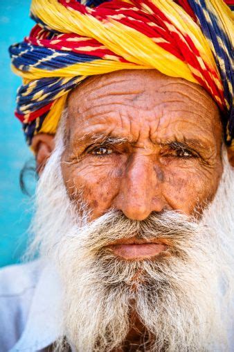 an old man with long white hair and colorful turban