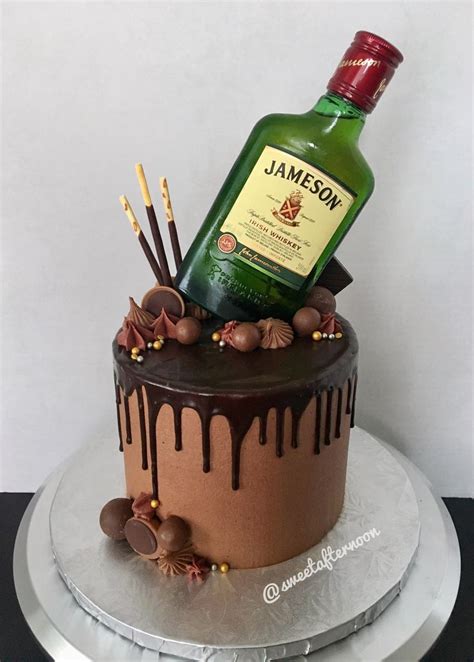 a bottle of jameson on top of a cake with chocolate icing and candies