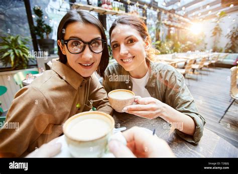 Content ladies resting in modern coffee shop Stock Photo - Alamy