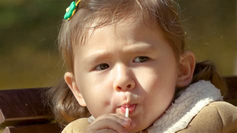 Premium stock video - Extreme close up, korean-ukrainian girl sucking on lollipop, yangjae park ...