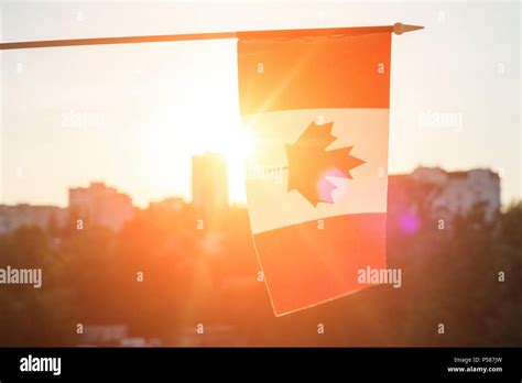 Flag of Canada from window on sunset background Stock Photo - Alamy