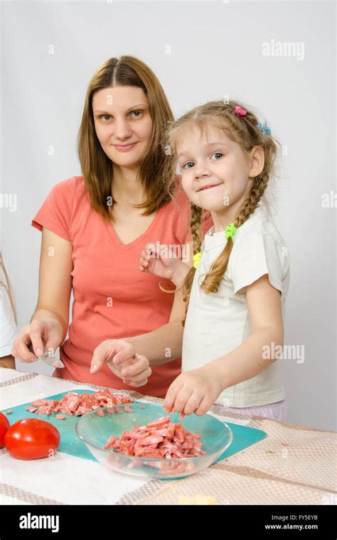 Little six year old girl helps mother to cook at the kitchen table Stock Photo - Alamy