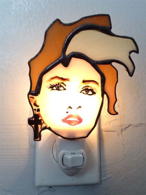 a light that is on the wall with a woman's face painted on it
