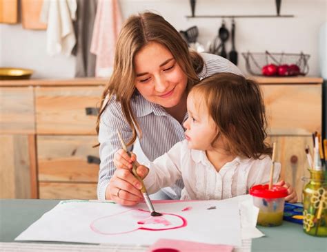 Free Photo | Mother and daughter painting heart on paper