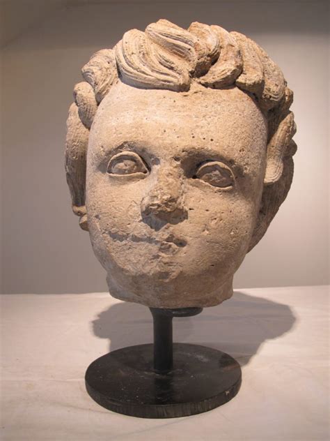 Stone statue of child’s head mounted on round metal base – BRENDA ANTIN