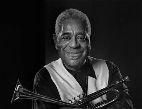 an old black and white photo of a man with a trumpet in his hands ...