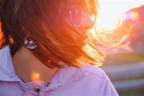 Young woman in sunglasses with messy hair at sunset · Free Stock Photo