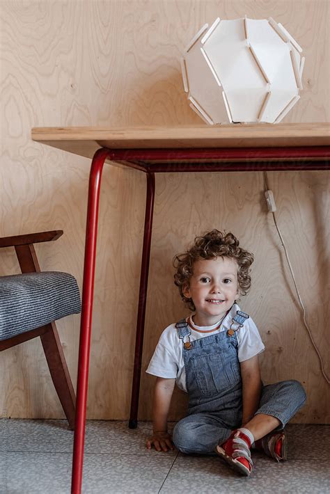 "Inquisitive Baby Crawling Under Table At Hone" by Stocksy Contributor "Alina Hvostikova" - Stocksy