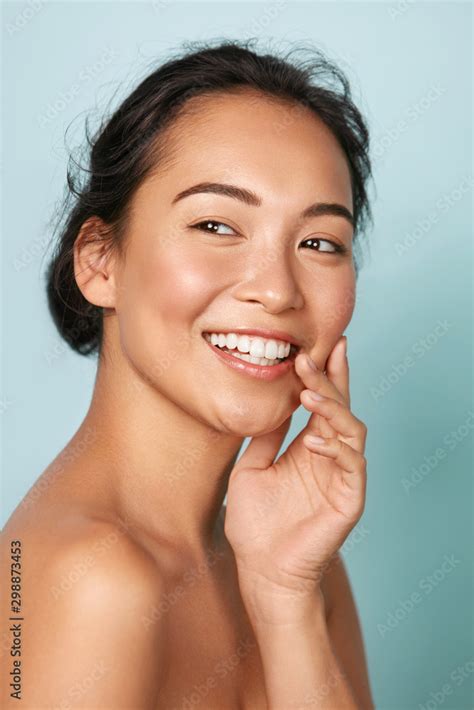 Beauty face. Smiling asian woman touching healthy skin portrait ...