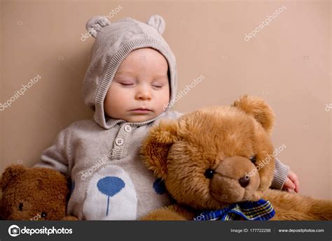 Sweet baby boy in bear overall, sleeping on a shelf with teddy b Stock Photo by ©t.tomsickova ...