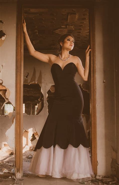 Elegant woman in dress standing near shabby doorway · Free Stock Photo