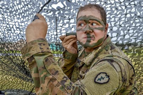 Army Spc. Sean Maxwell applies camouflage paint during Expert ...