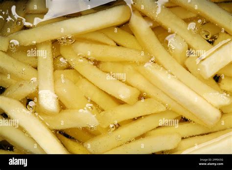 Cooking delicious french fries in hot oil, closeup Stock Photo - Alamy