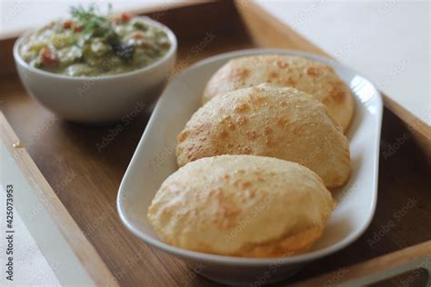 Deep fried indian flat bread served with mixed vegetable curry in a coconut cashew gravy Stock ...