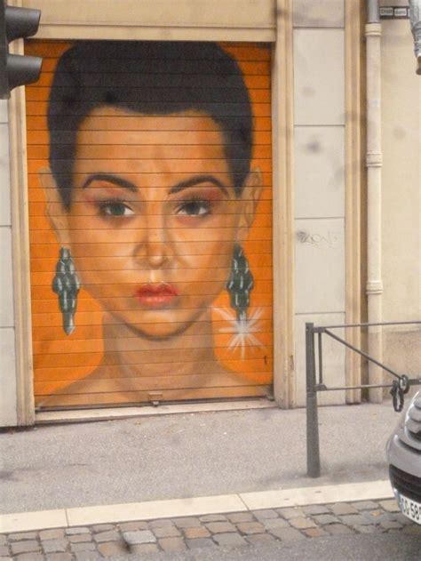 a car parked in front of a garage door with a painting on it's side