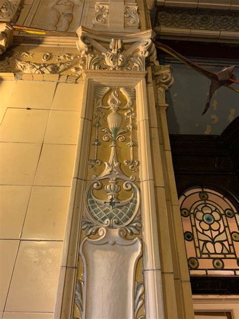 an ornate design on the side of a building with stained glass and metal work above it