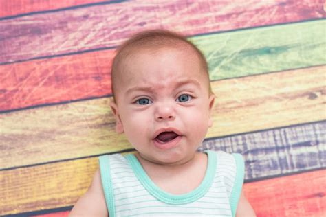 Premium Photo | Directly above portrait of cute baby boy crying while lying down on colorful ...