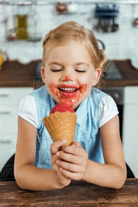 Adorable happy kid eating delicious sweet ice cream cone - Stock Photo - Dissolve