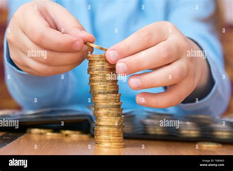 Child amassed a large pile of gold coins, close-up Stock Photo - Alamy