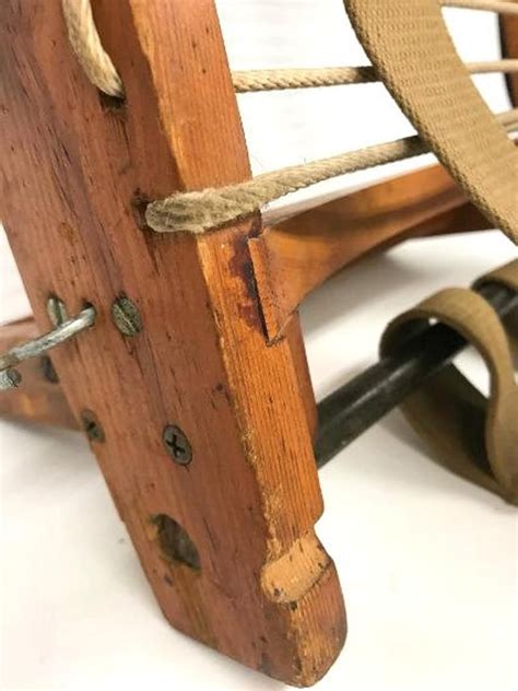 an old wooden rocking chair with rope on the front and back wheels ...