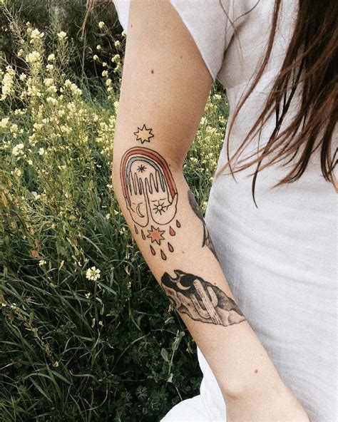 Colorful tattoos and double rainbows in a flower field