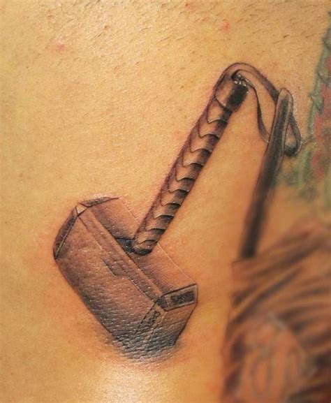 an image of a tattoo on the back of a man's stomach that has a hammer ...