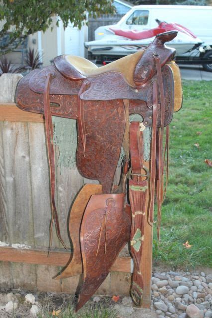 a horse saddle sitting on top of a wooden fence