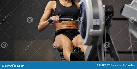 Powerful Attractive Muscular Woman CrossFit Trainer Do Workout on Indoor Rower at the Gym Stock ...