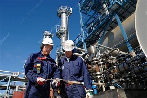 Oil refinery workers and pipework - Stock Image - F018/0886 - Science Photo Library