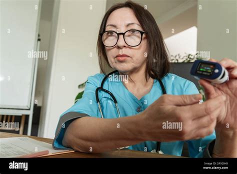 Doctor wearing eyeglasses showing pulse oximeter at medical practice Stock Photo - Alamy