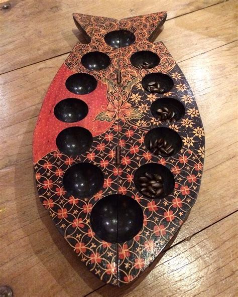 a wooden tray with black and red designs on it