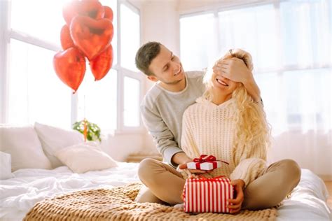 Premium Photo | Beautiful young couple at home celebrating Valentine's Day Lovers give each ...