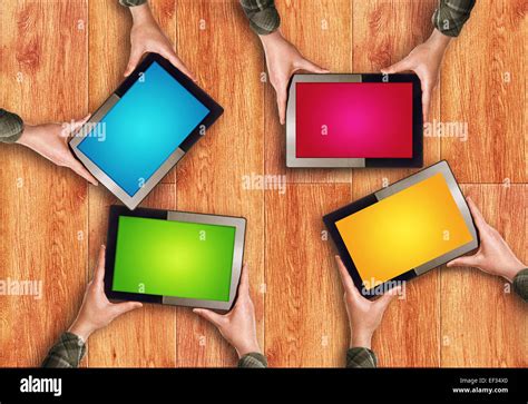 Hands Holding Four Digital Tablet Computers with Blank Colorful Screens as Copy Space over ...