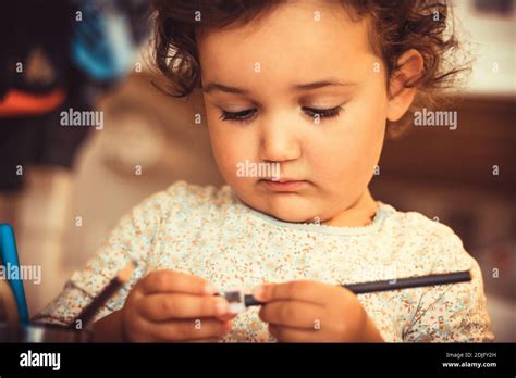 Little Girl Sharpening Crayons While Drawing At Home Stock Photo - Alamy