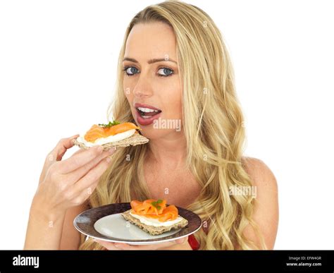 Happy Young Woman Eating Smoked Salmon and Cream Cheese on a Cracker Stock Photo - Alamy