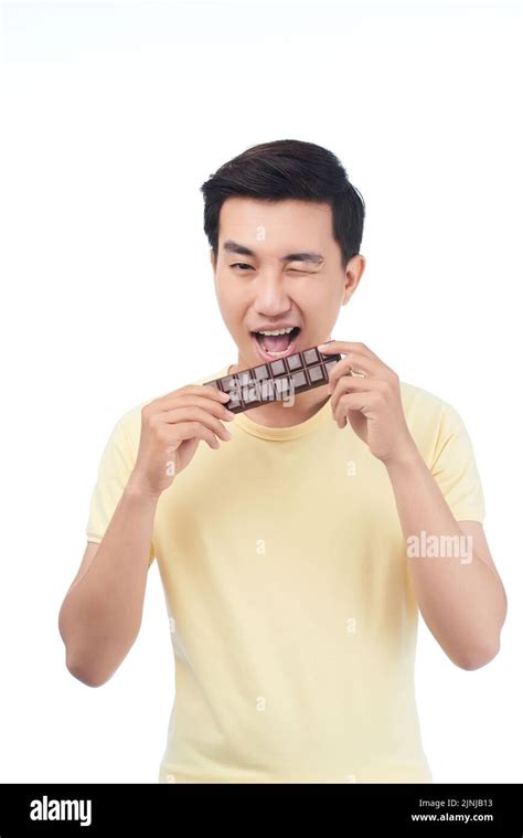 Winking young Vietnamese man eating milk chocolate Stock Photo - Alamy