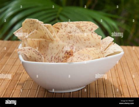 Tropical malanga chips outside in a white bowl by the palm trees Stock ...