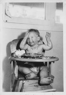 Baby on a high chair eats messily 2 | Undated | simpleinsomnia | Flickr