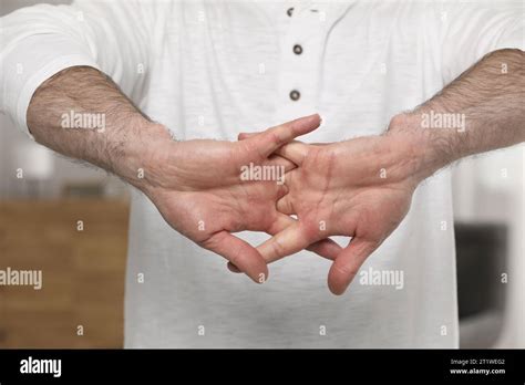Man cracking his knuckles on blurred background, closeup. Bad habit Stock Photo - Alamy