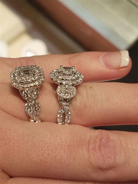 a woman's hand with two diamond earrings on top of her finger and the ...