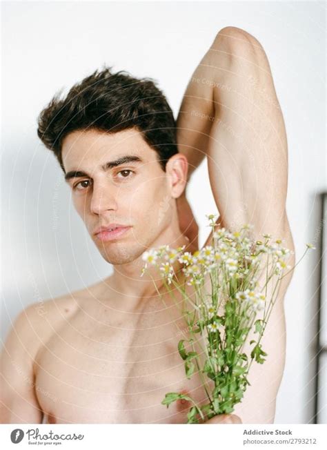 Young man with pink flowers - a Royalty Free Stock Photo from Photocase